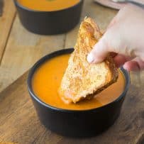 Dipping a grilled cheese sandwich in a bowl of 30 minute tomato basil soup