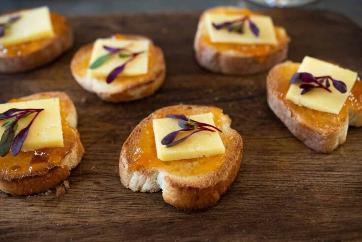 Toasted baguette slices topped with apricot preserves and white cheddar