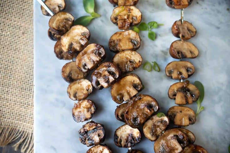 Mushrooms cut in half and threaded onto skewers and grilled