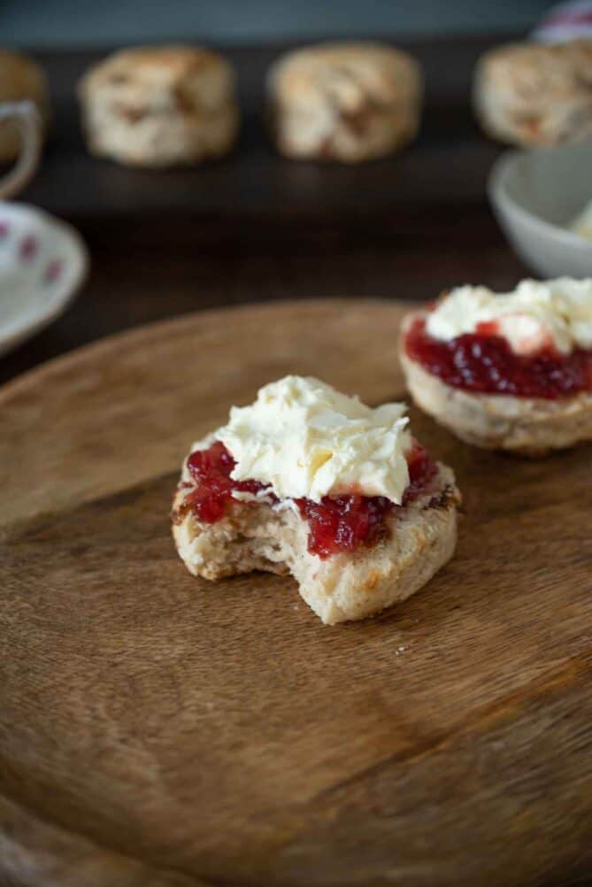 A bite taken out of a jam and cream scone