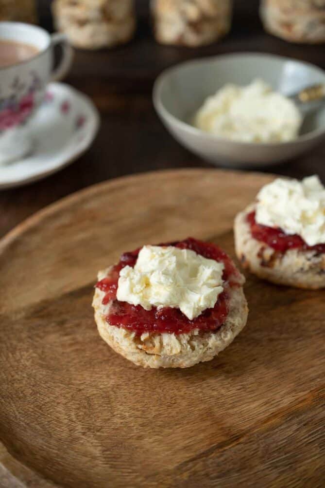 Clotted cream and strawberry jam on top of a scone half