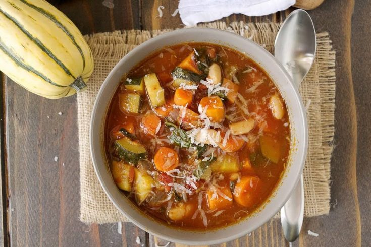 The soup viewed from overhead with a spoon and a delicata squash