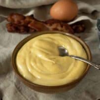 A bowl of mayonnaise with a spoon
