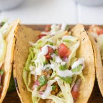 A healthy fish taco topped with pico de gallo, cabbage and crema