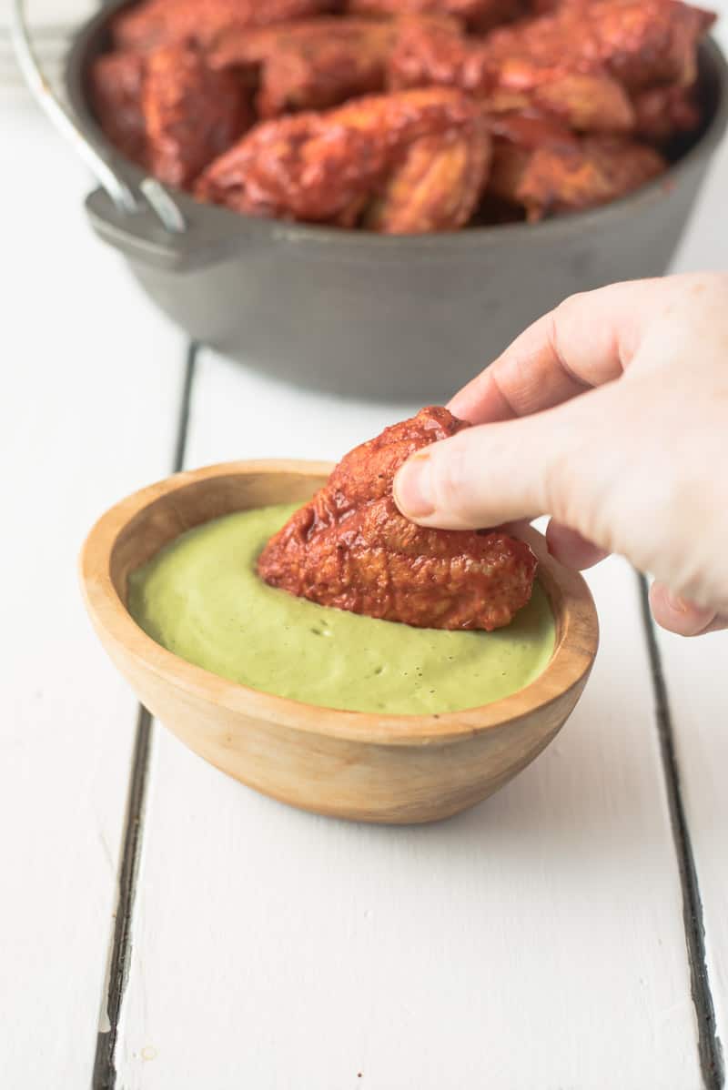 Dipping an adobo wing into avocado cream