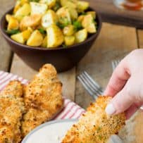 Dunking a breaded chicken tender into buffalo blue cheese sauce