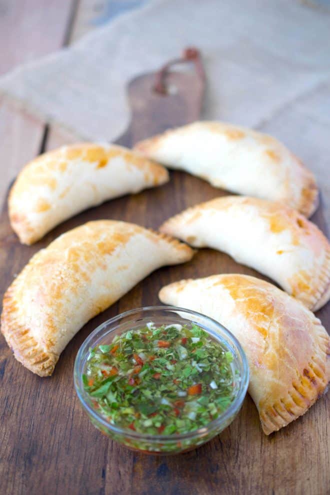 Colorful green chimichurri sauce with empanadas
