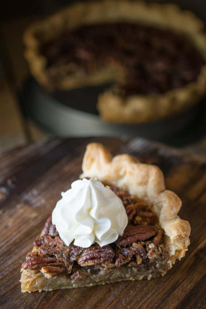 A slice of Bourbon Pecan Pie on a serving board