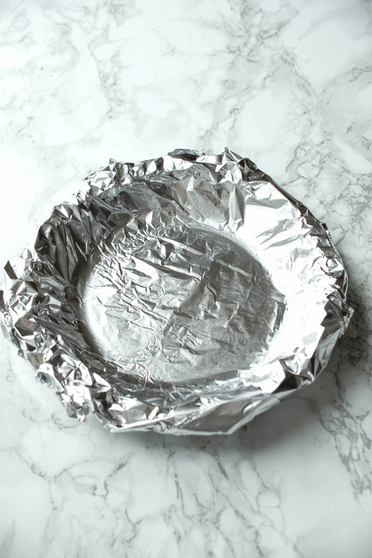 A pie crust covered with foil for blind baking