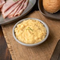 A silver bowl with Pease Pudding, ham and a bread roll