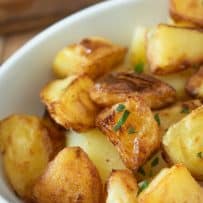 Crispy and browned roast potatoes garnished with chopped parsley