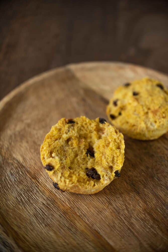 A pumpkin scone cut in half showing currants inside