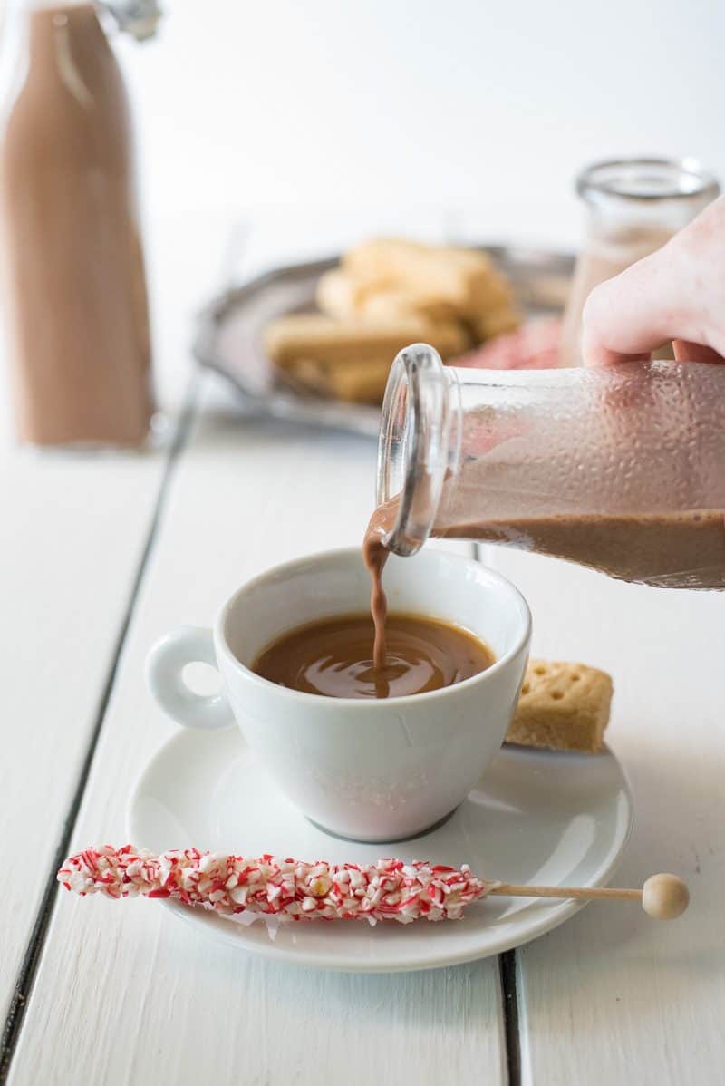 Pouring creamer into a coffee cup