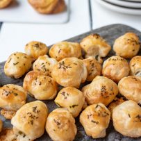 A selection of cheese, chive and rosemary puffs on a serving board
