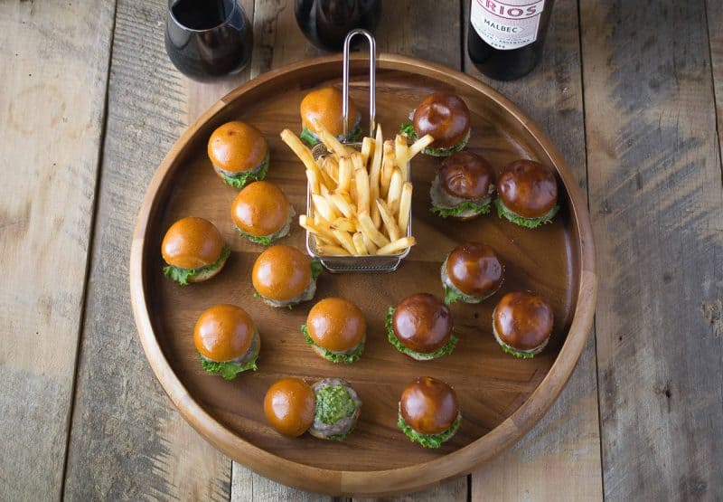 A platter of mini burgers with fries