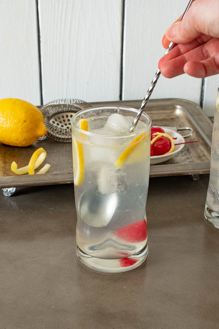 Stirring a glass of Tom Collins