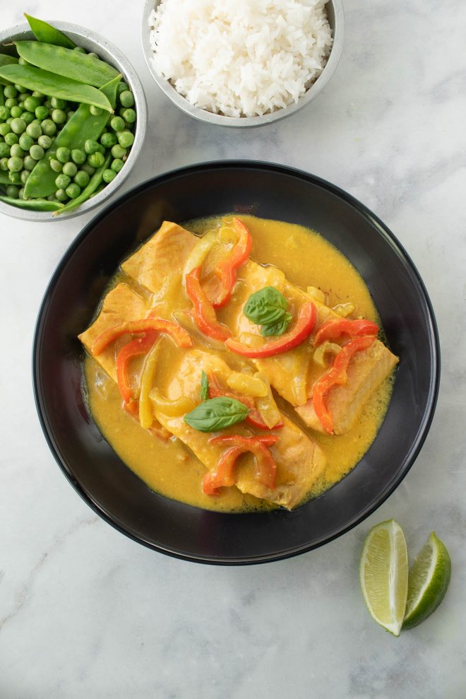 A view from above of 2 salmon filets in a bowl in curry sauce