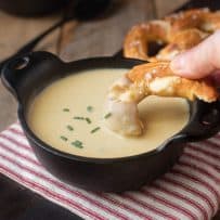 Dipping a soft pretzel into German beer cheese soup