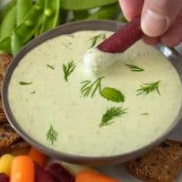 Dipping a carrot into creamy tzatziki dipping sauce