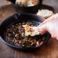 Dipping a piece of bread in to crispy bacon and sage in melted butter