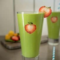 Detox green smoothie garnished with fresh strawberry slices