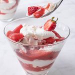 Meringue, strawberry and whipped cream on a spoon