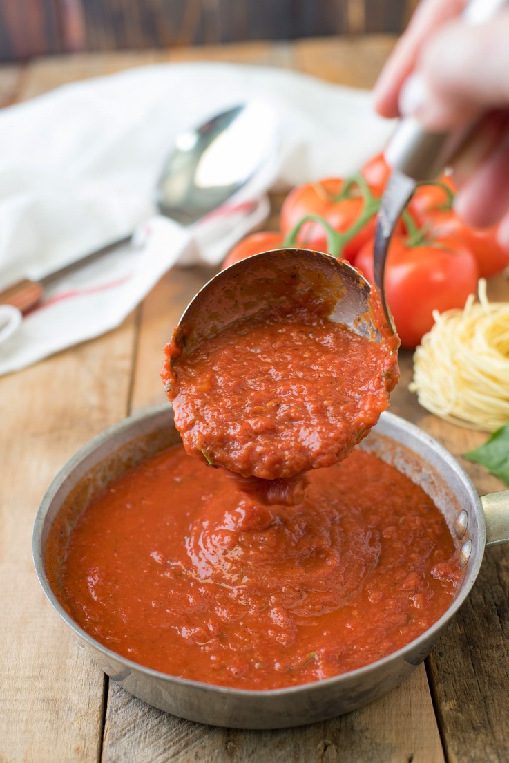 Marinara sauce being poured into a pan