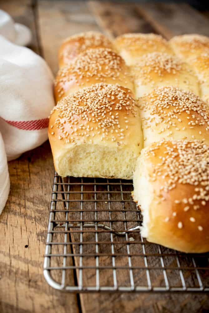 Sesame bread rolls on a cooling rack