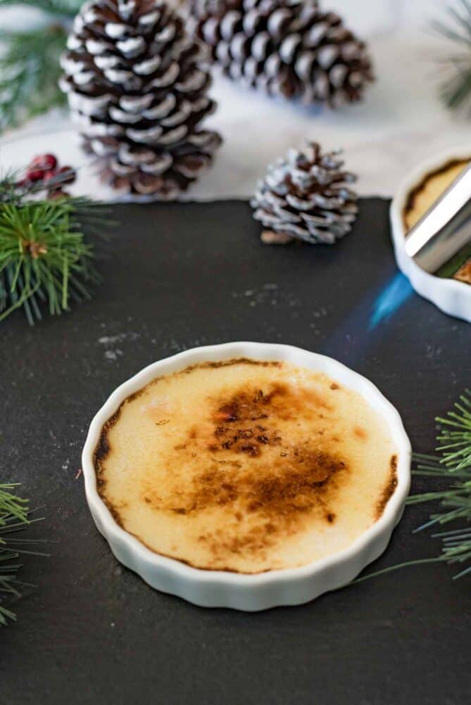 Using a kitchen blowtorch to brown and crisp sugar on top of creme br&ucirc;l&eacute;e