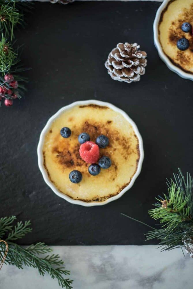 Eggnog creme br&ucirc;l&eacute;e viewed from overhead with pine cones