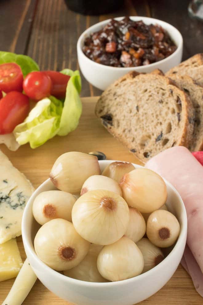 A white bowl full of English pickled onions