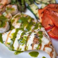 2 grilled chicken breasts topped with herb sauce