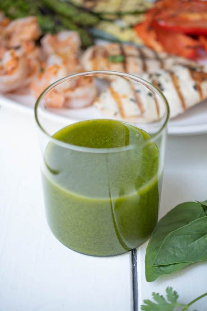 Vibrant green herb sauce in a glass storage jar