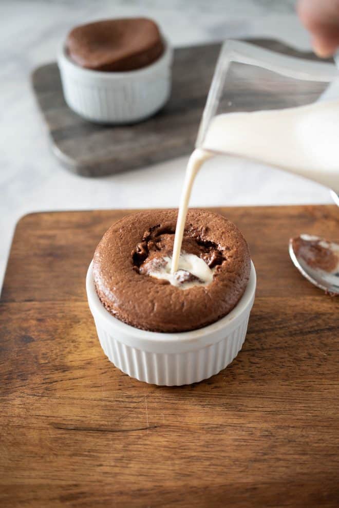 Pouring vanilla sauce into the center of the souffl&eacute;