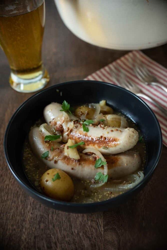 German beer sausage and potatoes in a black bowl