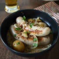Pale sausages and potatoes stew in a bowl