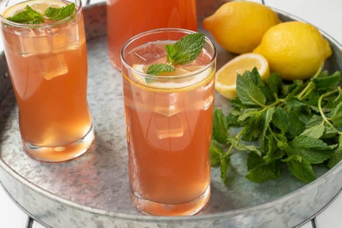 Ginger mint lemonade in a glass garnished with lemon and fresh mint