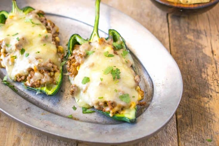 Grilled beef stuffed poblano peppers on a silver plate