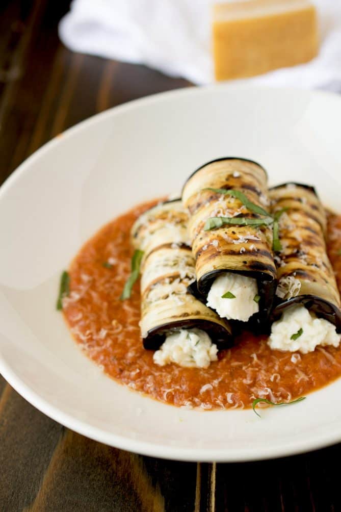 3 slices of eggplant rolled up and filled with ricotta served on a bed of tomato sauce