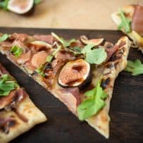 A closeup showing a sliced fig drizzled with balsamic glaze