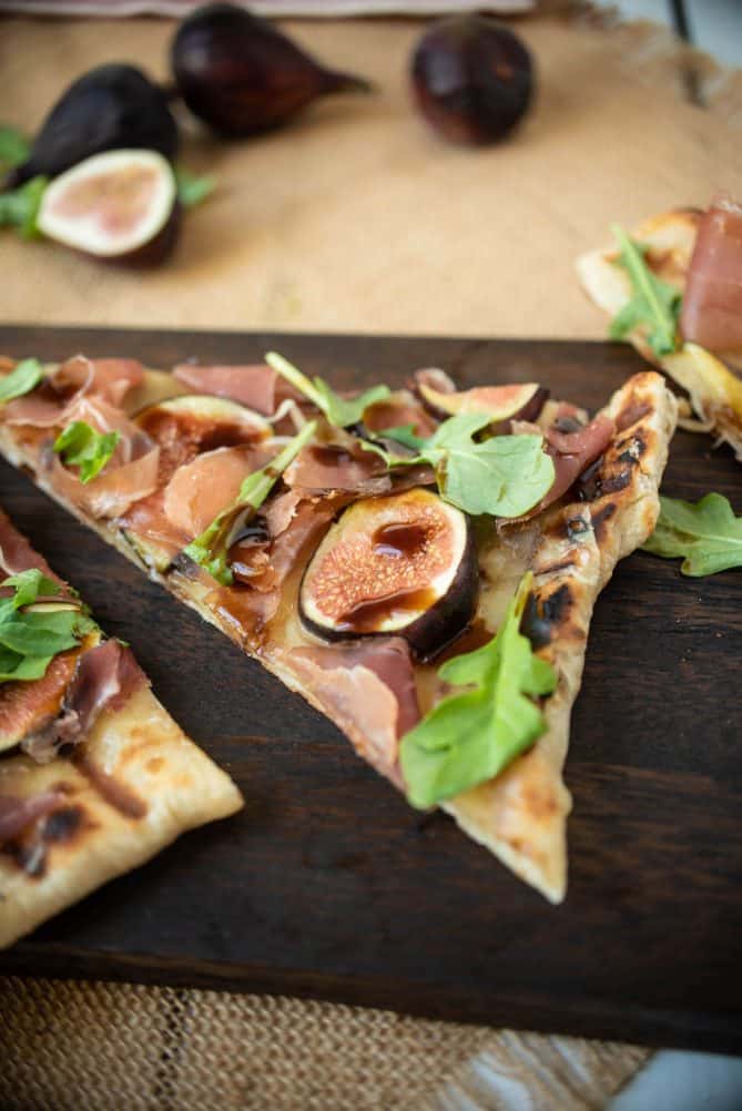 A closeup showing a sliced fig drizzled with balsamic glaze