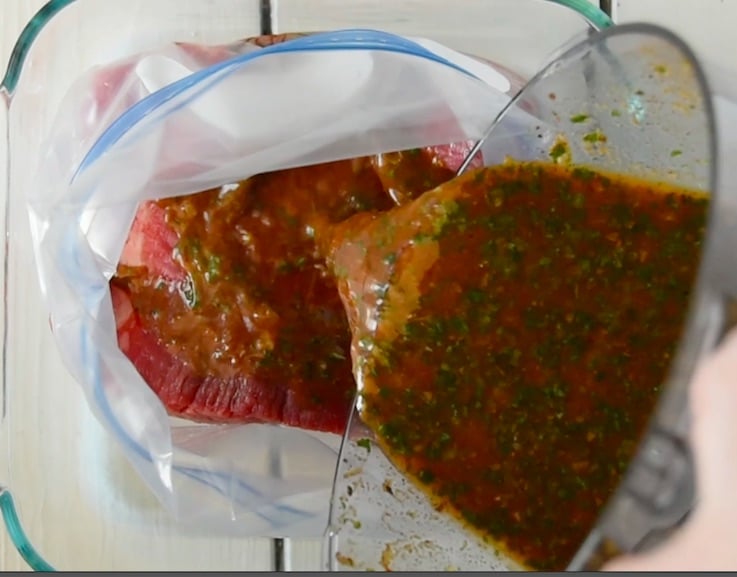 Pouring the marinade over the flank steak