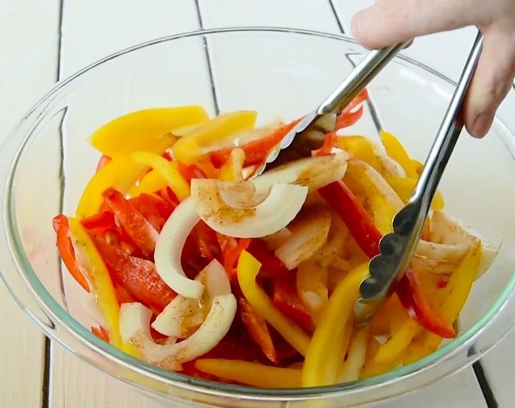 Tossing the spices with the peppers and onions