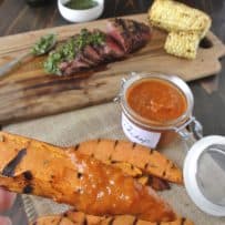 A grilled sweet potato wedge dipping in curry ketchup
