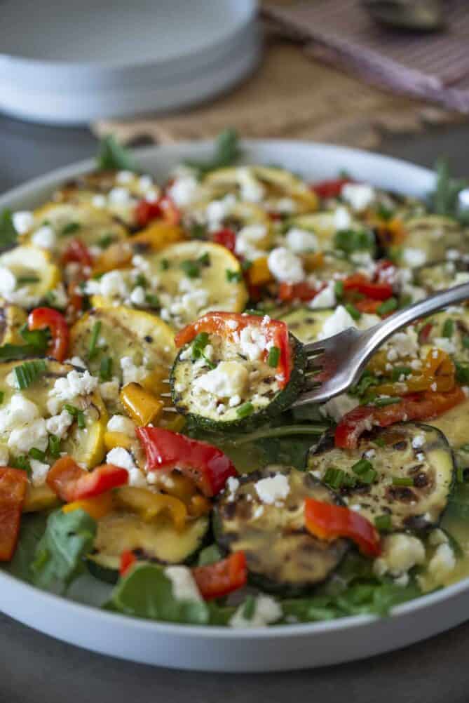 A slice of zucchini and grilled pepper on a fork