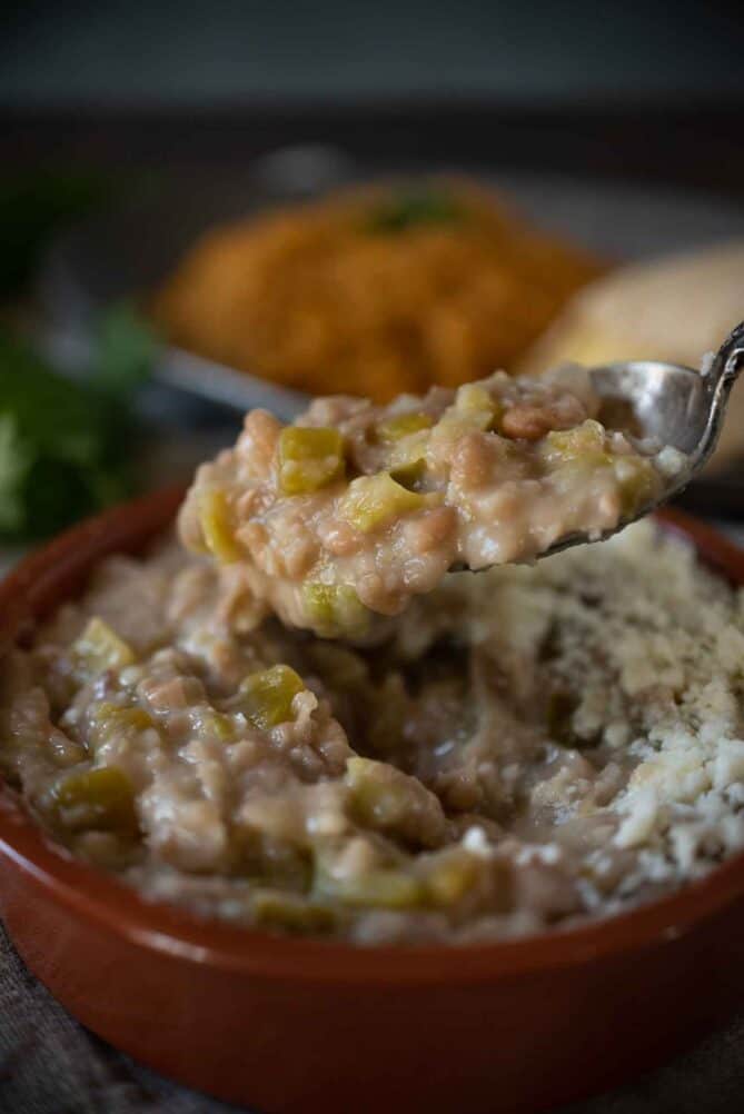 A spoonful of refried beans studded with hatch chile peppers