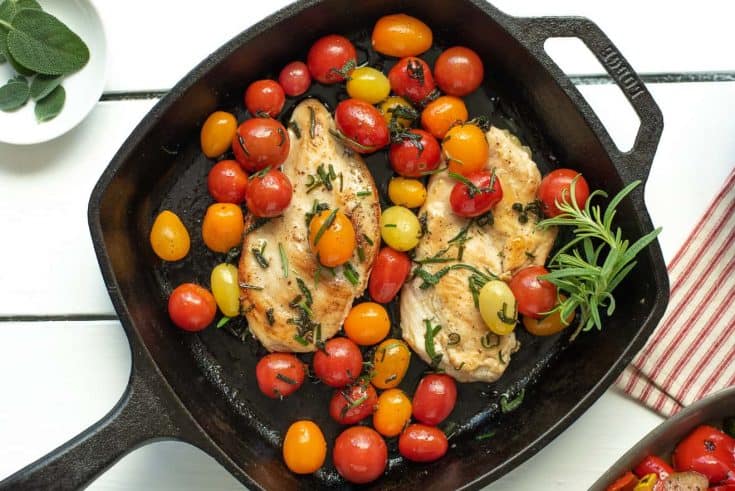 Herbed Brown Butter Chicken with Tomatoes in a cast iron skillet garnished with fresh rosemary