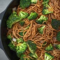 A cast iron skillet filled with noodles and broccoli