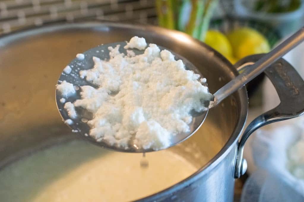 Ricotta starting to thicken on a spoon