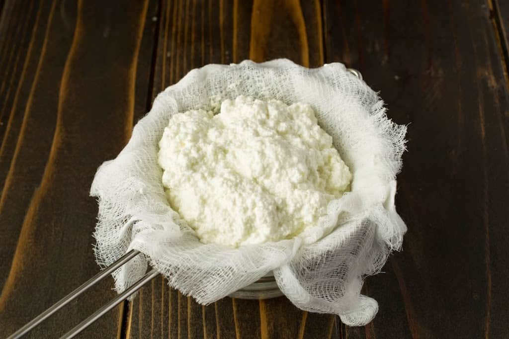 Ricotta draining through cheesecloth